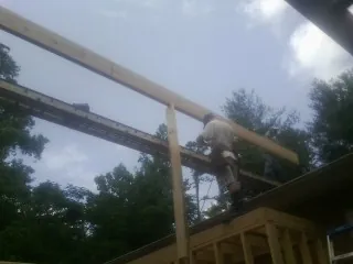 Carpenter setting a ridge beam over a new addition frame — Ice Dam Removal by Roofing Brothers in Jarrettsville