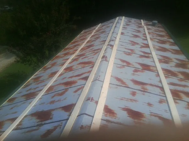 Rusted metal roof panels with new wood purlins before replacement — Storm Damage Roof Repair in Jarrettsville by Roofing Brothers